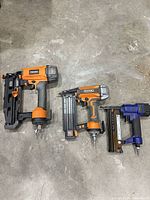 Three nailers side by side on floor