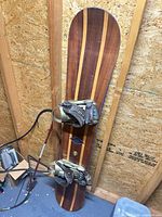 Top view of snowboard showing laminated wood topsheet and bindings