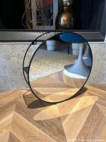 front view of circular mirror within black metal frame