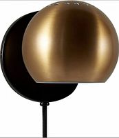 Front view of brushed gold half-dome sconce on black backplate with cord