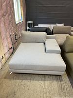 Front angled view of chaise lounge showing upholstery, armrest and back cushion