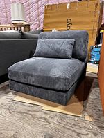 Front view of gray-blue corduroy armless chair with lumbar cushion