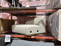 Overall view of orange steel pallet rack holding furniture, shows beam style and upright profile