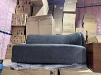 Side view of grey settee on boxes with bubble wrap