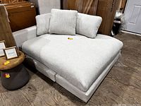 Front view of oversized light gray chaise with cushions