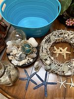 Overall lot showing tub, bowl of shells, glass floats, wreath and starfish