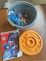 Open bucket with contents, lid and manual visible