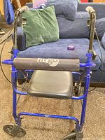 Front view showing blue Hugo rollator, seat, hand brakes