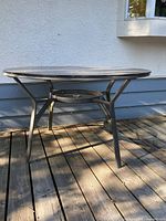 full view of round glass patio table on deck