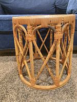 Full view of rattan side table alongside sofa