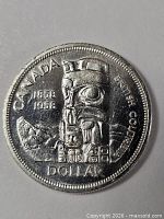 Reverse of 1958 Canada silver dollar showing totem pole design and dates