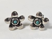 Frontal view of both earrings showing flower shape and turquoise centers
