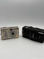 Front view of both Canon cameras, showing model shapes and wear on SD70