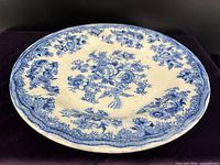 Oblique view of plate showing floral and bird pattern and edge detail