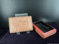 Lidded box and base separated showing carved lid scene and black interior