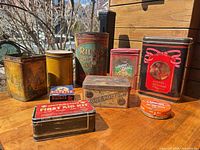 Group shot of all tins on tabletop showing fronts.
