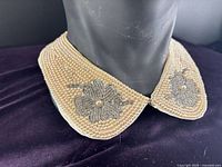 Collar on mannequin neck showing beadwork and floral motifs