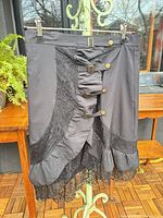 Front view of black Gothic skirt showing lace panels, buckles, buttons, ruffle and lace hem