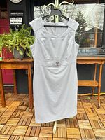 Front view of light gray sleeveless sheath dress on hanger
