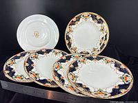Front and back view of six Empress dessert plates with ruler for scale