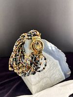 Multi-strand beaded bracelet with gold-tone covered watch case