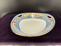 Top view showing blue band, gold gilt scrollwork, red accents, and white center