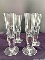 Front view of four starburst etched cordial glasses