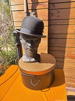 Bowler hat on mannequin next to hat box