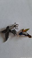 Both hummingbird brooches side by side