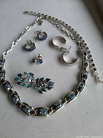 Full set laid out showing necklace, bracelet, four earring pairs