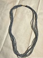 Full view of necklace laid flat showing multi-strand construction and clasp