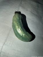 Full view of green pickle ornament lying flat