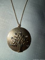 Close-up of pendant showing tree motif and rhinestones