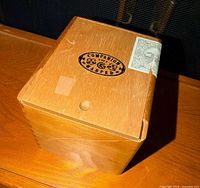 Top view of wooden cigar box showing logo and tax stamp