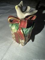 Front view of ceramic Fitz and Floyd dove on wrapped present figurine