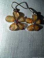 Front view of both earrings showing flower design, yellow petals, rhinestone centers