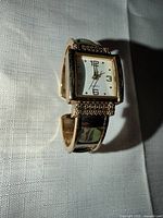 Front view of square-face gold-tone cuff watch