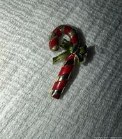 Front view showing red and gold striped candy cane with green bow