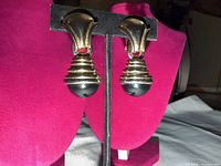 front view showing gold-tone ribbed bodies and black stone drops