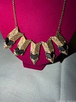 Front view of goldtone necklace on display bust