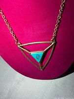 Close-up of pendant front highlighting turquoise inset and gold-tone frame