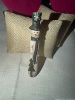 Front view of carved wooden snowman brooch