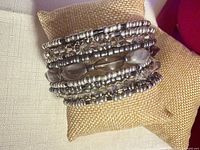 Front view of wide gray crystal and pearl cuff bracelet on display pillow