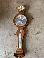 Full view of wooden Howard Miller weather station