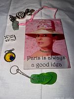 All items laid out on cloth surface including sign, keychains, dice, figurine, charm