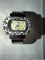 Front view of Narmi cuff watch showing dial and leopard bezel