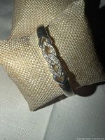 Full view of silver-tone bangle on display pillow