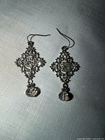 Front view of both earrings showing filigree pattern, rhinestone centres and crystal drops