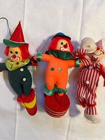 Front view of all three fabric clown ornaments showing colors and design