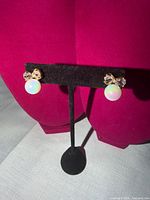 Front view of both earrings on stand showing design details